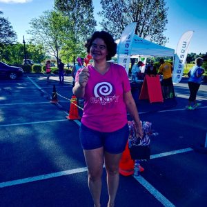 woman in a candy shirt handing ut candy with a smile