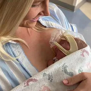 Mom holds baby in NICU.