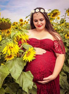 Expectant mother in a field of sunflowers