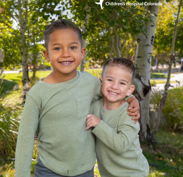 Smiling young brothers wrap each other in a hug