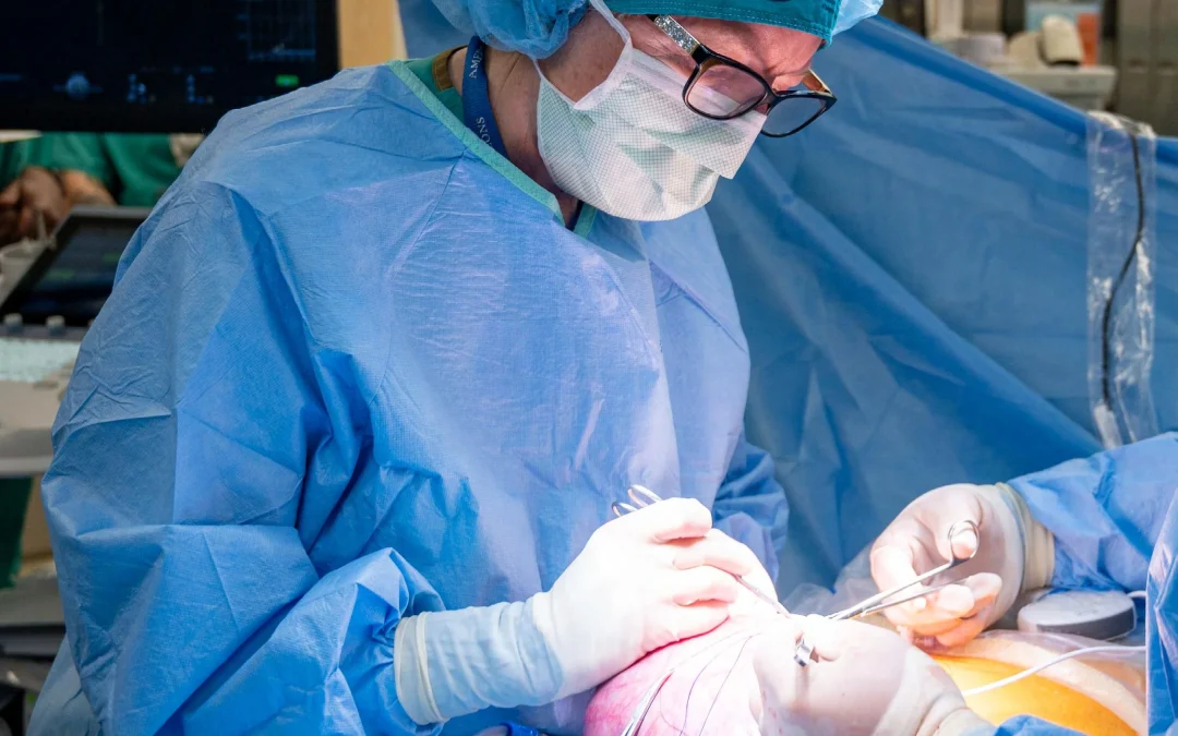 Doctor in surgical scrubs operates on pregnant woman