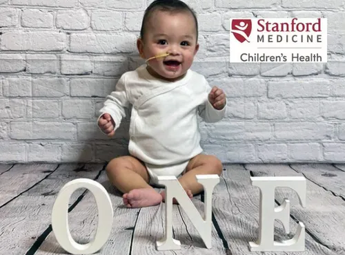 One year old baby sits up independently with a naso-gastric tube