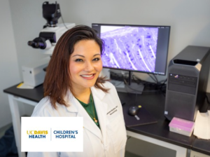 Female doctor stands in front of her microscope in the lab 